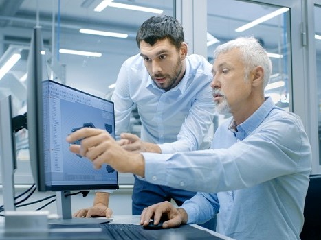 Workers discussing at a computer.